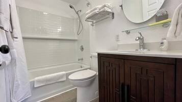 Et moderne badeværelse med badekar, toilet og vaskemøbel.