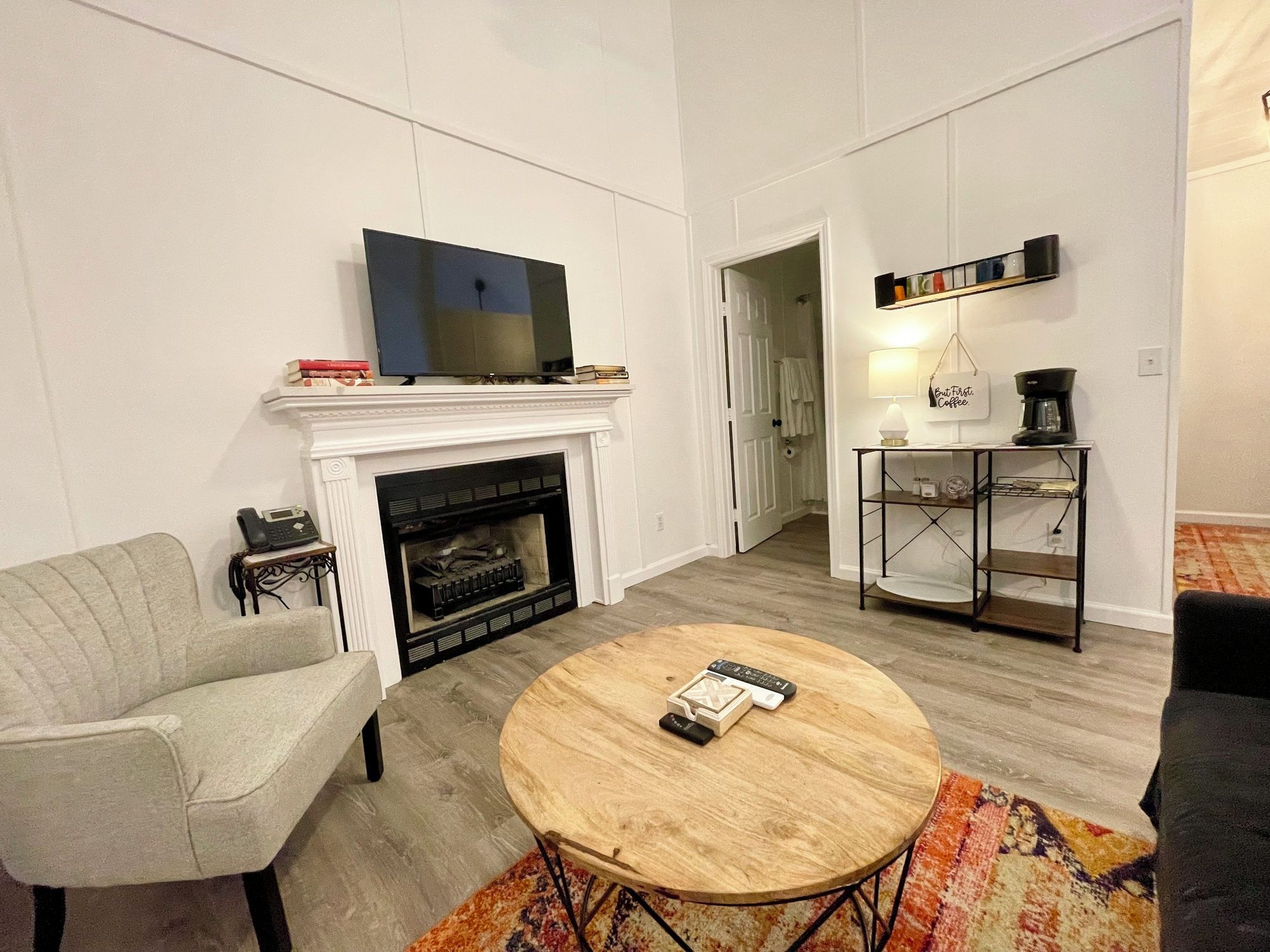 A living room with a fireplace, a television, a coffee table, and a sofa.