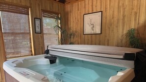 A hot tub with a wooden interior, a framed artwork on the wall, and a window with a bamboo screen. - Heber in the Woods/Hot Tub/4% wkly discount/Hiking (Heber-Overgaard)