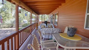 A covered porch with wicker chairs and a table, an American flag, and a grill in the background. - Heber in the Woods/Hot Tub/4% wkly discount/Hiking (Heber-Overgaard)