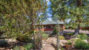 A lodge with a stone pathway leading to a red building, surrounded by dense trees and a variety of plants. - Heber in the Woods/Hot Tub/4% wkly discount/Hiking (Heber-Overgaard)