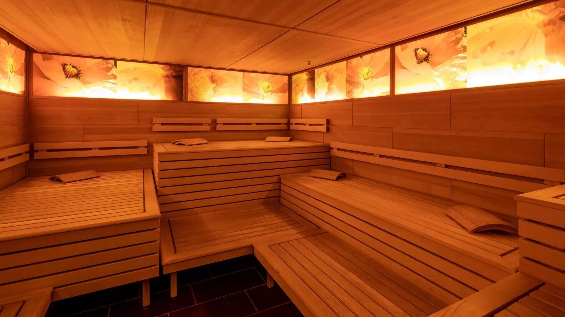 A sauna with wooden benches and benches, and a tiled floor.