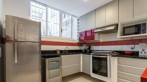A modern kitchen with stainless steel appliances, a red tiled backsplash, and white cabinetry. - 4 minutes from Copacabana beach | NSC205 (Rio de Janeiro)