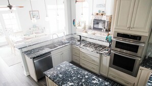 A modern kitchen with granite countertops, stainless steel appliances, and light-colored cabinetry. - Luxurious Large Home on Gulf of Mexico w/Private 30' Dock (Englewood)