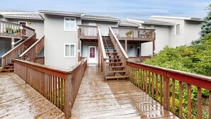 A residential building with multiple balconies, wooden staircases, and a wooden deck. - Cozy Mountain Retreat: Single-Level Condo in Sugar Mountain with Modern Comforts (Sugar Mountain)