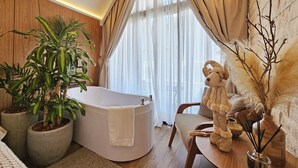 A modern bathroom with a freestanding bathtub, large potted plants, and a decorative statue. - Pinot Noir Cabin - Urban Cabin (Bento Gonçalves)