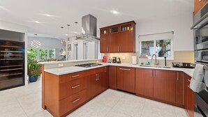 Une cuisine moderne avec des meubles en bois, un îlot central et un four encastré.