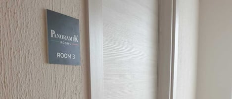 Una puerta con un letrero que indica "PanoramiK Rooms HABITACIÓN 3".