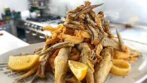 A plate of fried fish with lemon wedges. - Panoramik  (Acri)