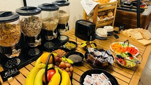 A buffet table with various food items, including cereals, fruits, and condiments. - Hotel Thesdorfer Hof (Pinneberg)