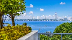 A coastal cityscape with a clear view of the water and buildings in the distance. - Relax with Pool, Gym, Balcony in Design District (Miami)