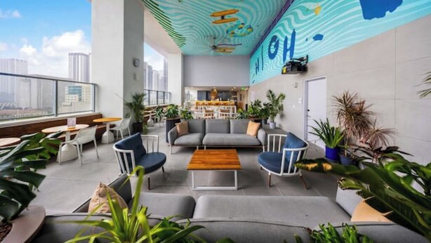 A modern lounge area with seating, a coffee bar, and a view of the city. - Penthouse Studio in heart of Miami w pool & gym (Miami)