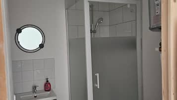 Een douche, een haardroger, handdoeken, toiletpapier