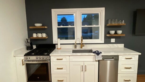 A kitchen with white cabinets, a double sink, a stove, and a dishwasher. - mi casa es TU casa (EAST) (Upland)