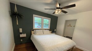 A bedroom with a bed, a ceiling fan, a window, and a door. - mi casa es TU casa (Center) (Upland)