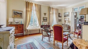 Ein großzügiges Wohnzimmer mit großem Fenster, Kamin und Essbereich.