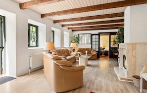 A spacious living room with a fireplace, leather sofas, and a wooden ceiling. - Beautiful home in Nørre Aaby with sauna (Nørre Aaby)