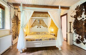 A four-poster bed with a canopy, a zebra-patterned curtain, and a cow-hide wall. - Beautiful home in Nørre Aaby with sauna (Nørre Aaby)
