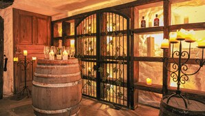 Un intérieur rustique agrémenté de barils en bois, d’un portail en fer forgé et de bougies.