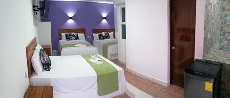 Habitación de hotel con dos camas, un televisor y un cesto de basura.