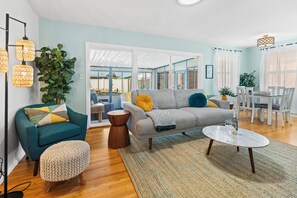 A living room with a sofa, armchairs, a coffee table, and a dining area with chairs and a table. - 3 bedroom Central Escape - Hot Tub, Fire Pit & newly renovated sunny back yard (San Diego)