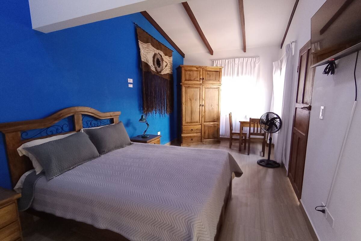 Un dormitorio con cama, escritorio y silla.