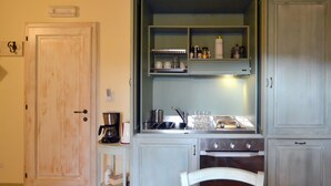 A compact kitchen with a coffee maker, wine glasses, and a stove. - Pet friendly apartment (Ponte alla Piera)