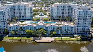 A large hotel complex with multiple high-rise buildings, a central courtyard with a fountain, and a surrounding body of water.