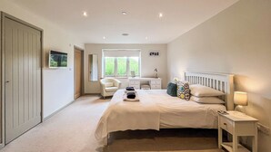 A bedroom with a bed, bedside table, lamp, chair, desk, and wardrobe.