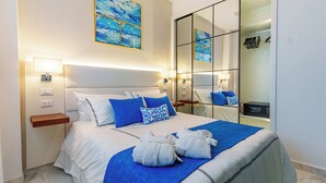 A hotel room with a large bed, a bedside table, a nightstand, a mirror, and a wardrobe. - Airbn Be Luxe Best Golf  view Cana Rock Star E 304 (Bavaro)
