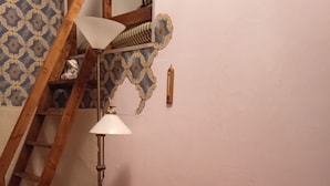 A small room with a wooden desk, a chair, a lamp, and a patterned wall. - LDL-LUSIV 1-room apartment 2 ground floor with staircase lyft (Bad Camberg)