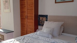 A bedroom with a wooden wardrobe, a bed with white bedding, and a framed picture on the wall. - LDL-LUSIV 1-room apartment 2 ground floor with staircase lyft (Bad Camberg)
