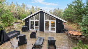 A cabin with a deck, outdoor seating, and a dining area. - Beautiful home in Blokhus with sauna (Blokhus)