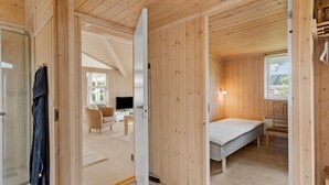 A wooden interior with a bed, a TV, and a seating area. - Nice home in Væggerløse with WiFi (Væggerløse)