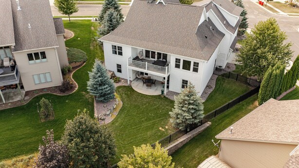 Une maison à deux étages avec un patio couvert et une cour clôturée.