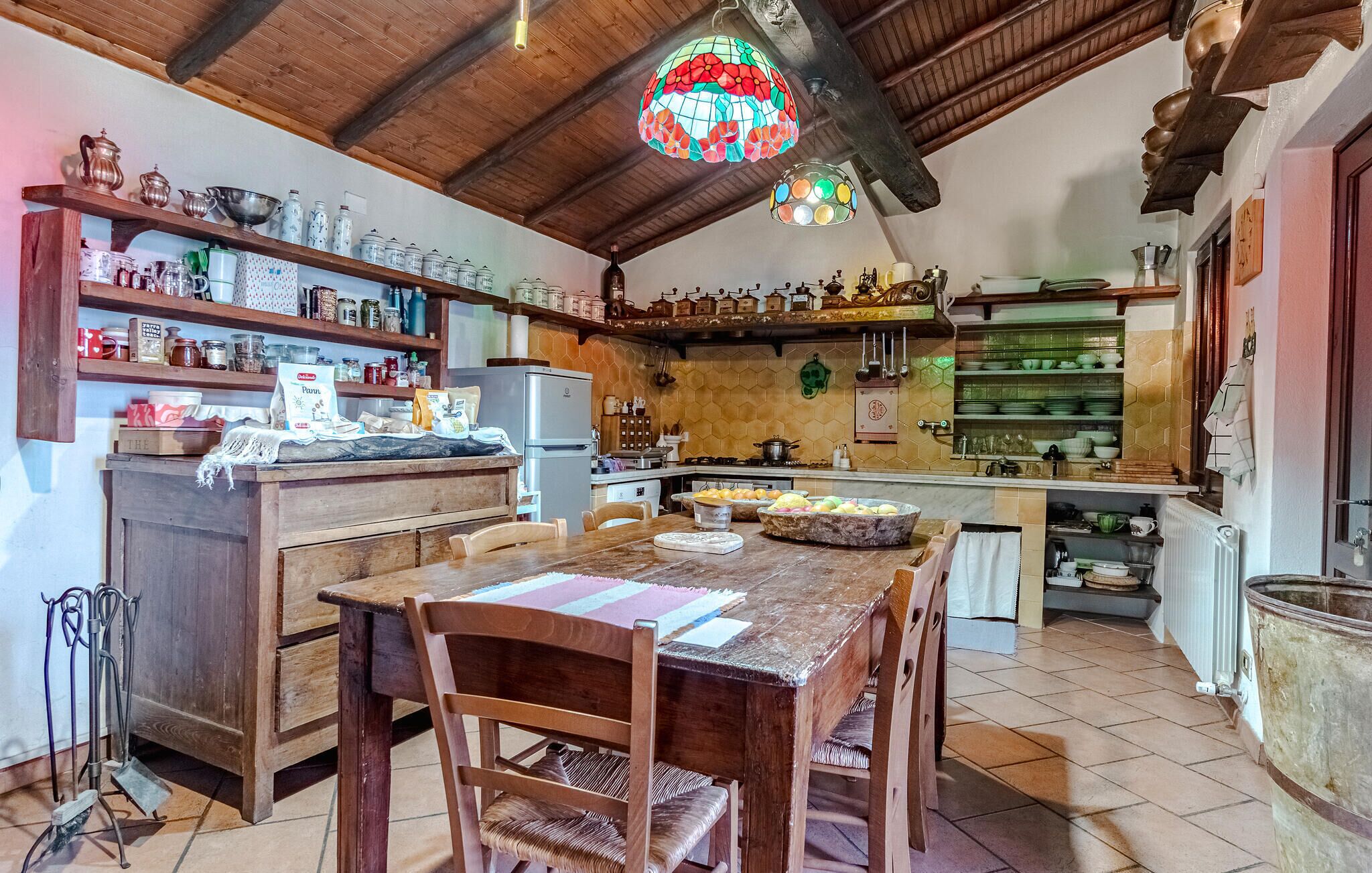 Une cuisine rustique avec des meubles en bois, un îlot central et des luminaires suspendus.