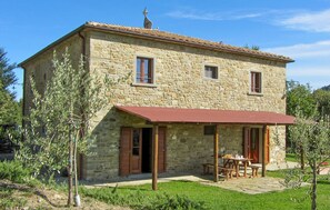 A stone house with a red roof, a covered patio, and a small garden. - Amazing apartment in Ponte alla Piera (Ponte alla Piera)