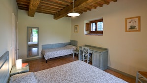 Ein Schlafzimmer mit zwei Betten, einem Schreibtisch und einem Fenster.