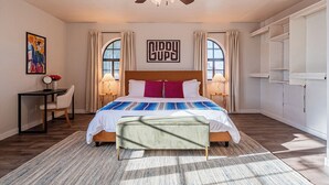 Un dormitorio con cama, mesitas de noche, un escritorio y un ventilador de techo.