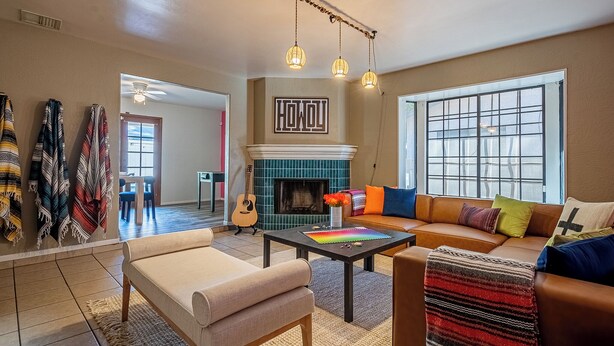 Una sala de estar con chimenea, un sofá, una mesa de centro y una guitarra.