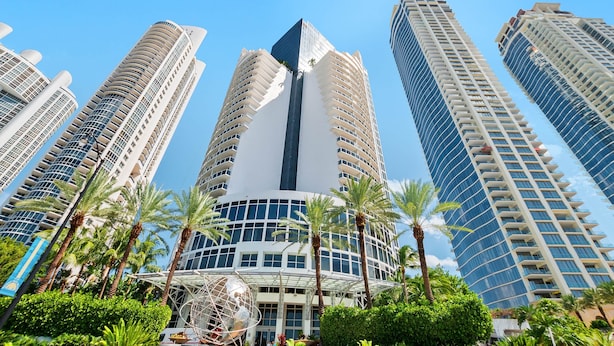 A high-rise building with a modern design, featuring multiple balconies and a central glass facade. - 1910 International  Resort Deluxe 2 Queen  Ocean Front (Sunny Isles Beach)