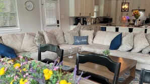A modern living room with a sofa, chairs, a coffee table, and a floral centerpiece.