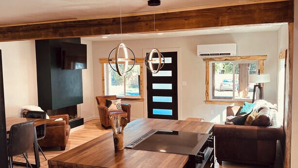 A modern kitchen with a wooden island, black chairs, and a dining table. - Luxury Living Near Downtown Moscow & U of I Campus (Moscow)