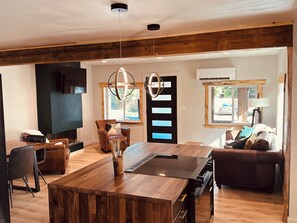 A modern kitchen with a wooden island, black chairs, and a dining table. - Luxury Living Near Downtown Moscow & U of I Campus (Moscow)