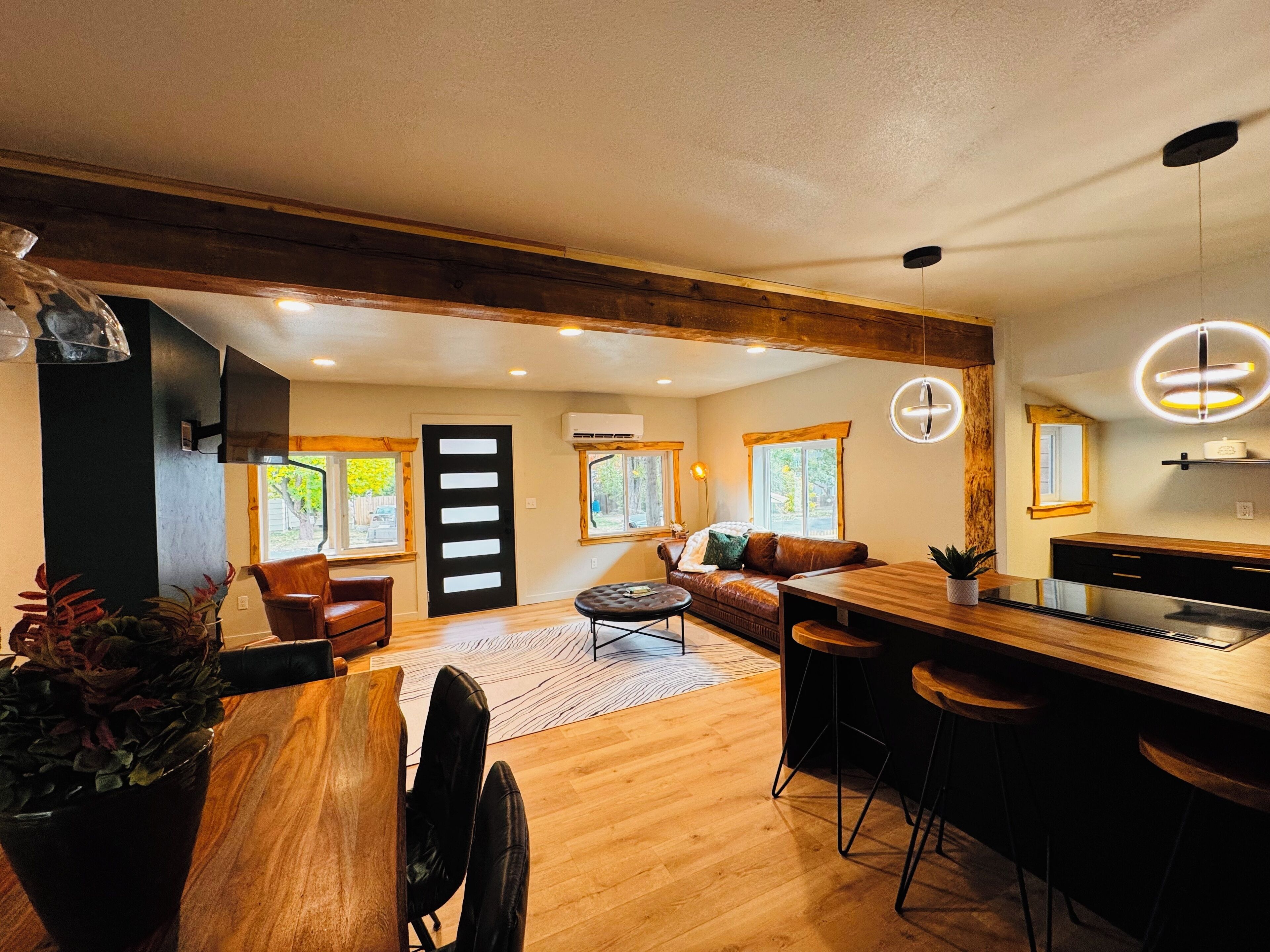 Une cuisine moderne avec un plan de travail en bois, des tabourets de bar et une table à manger.