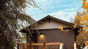 A two-story wooden cabin with a balcony, outdoor seating, and a stone pathway. - Luxury Living Near Downtown Moscow & U of I Campus (Moscow)