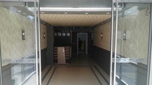 Ein Empfangsbereich mit einer Rezeption, einer Uhr und einer Wand mit geometrischem Muster.