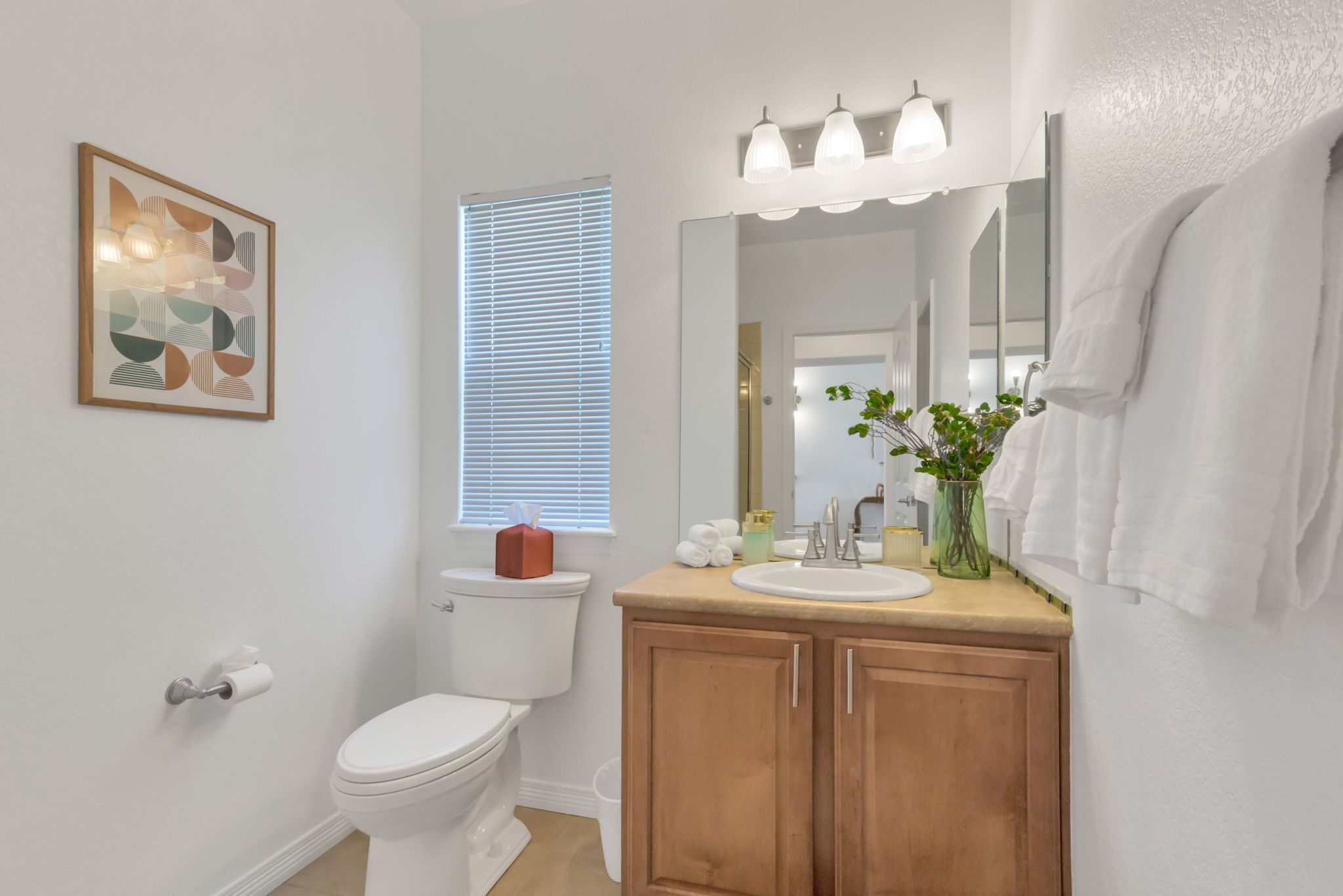 A modern bathroom with a toilet, sink, and vanity.