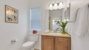 A modern bathroom with a toilet, sink, and vanity.