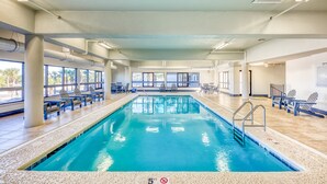 Una piscina interior d'aigua turquesa, envoltada de gandules i un paviment de rajoles.